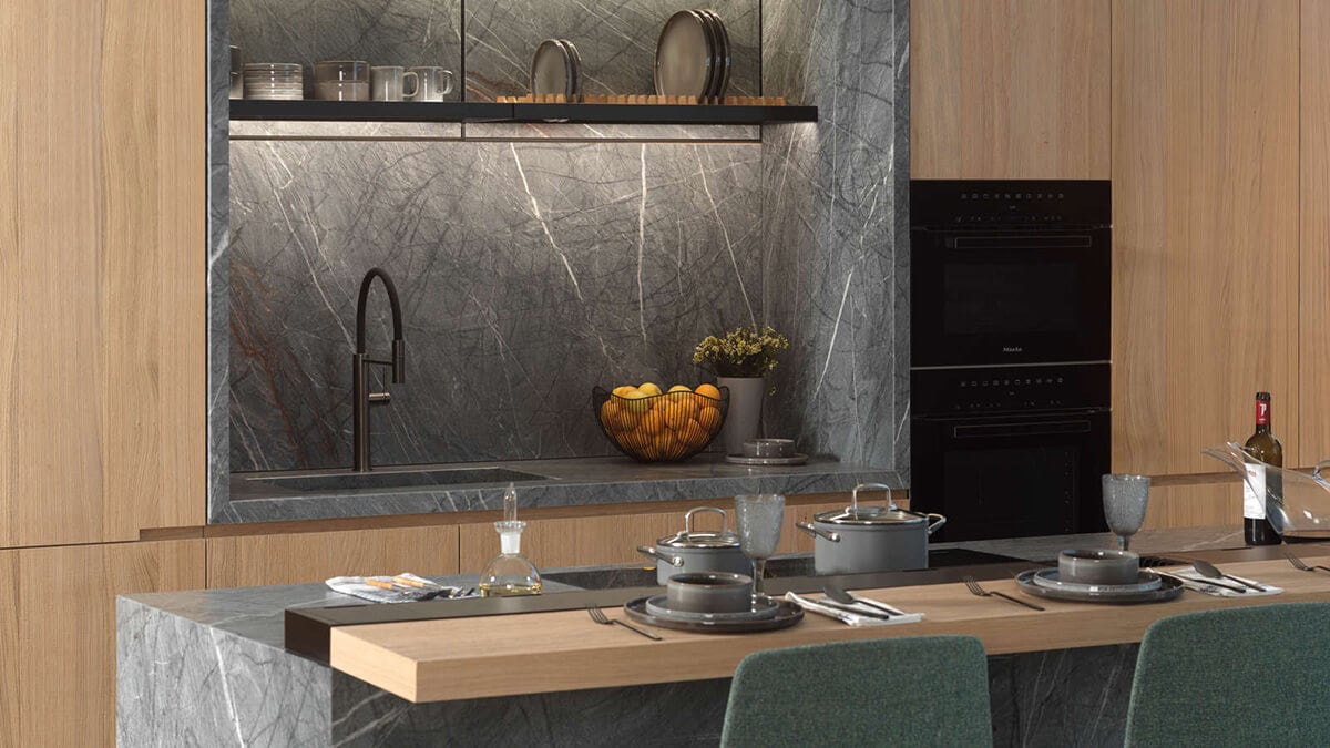 Кухня з дерев’яними шафами та стільницею та задньою панеллю від Porcelanosa