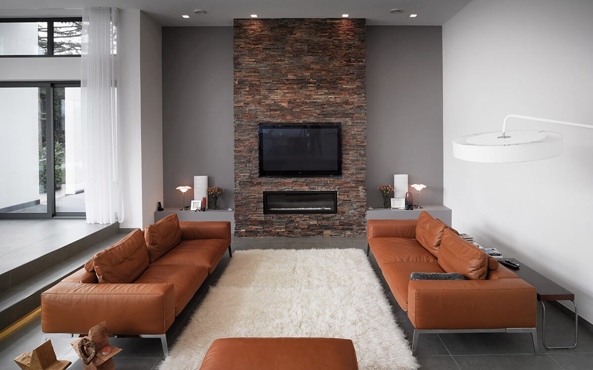 Living room with split face tiles fireplace wall